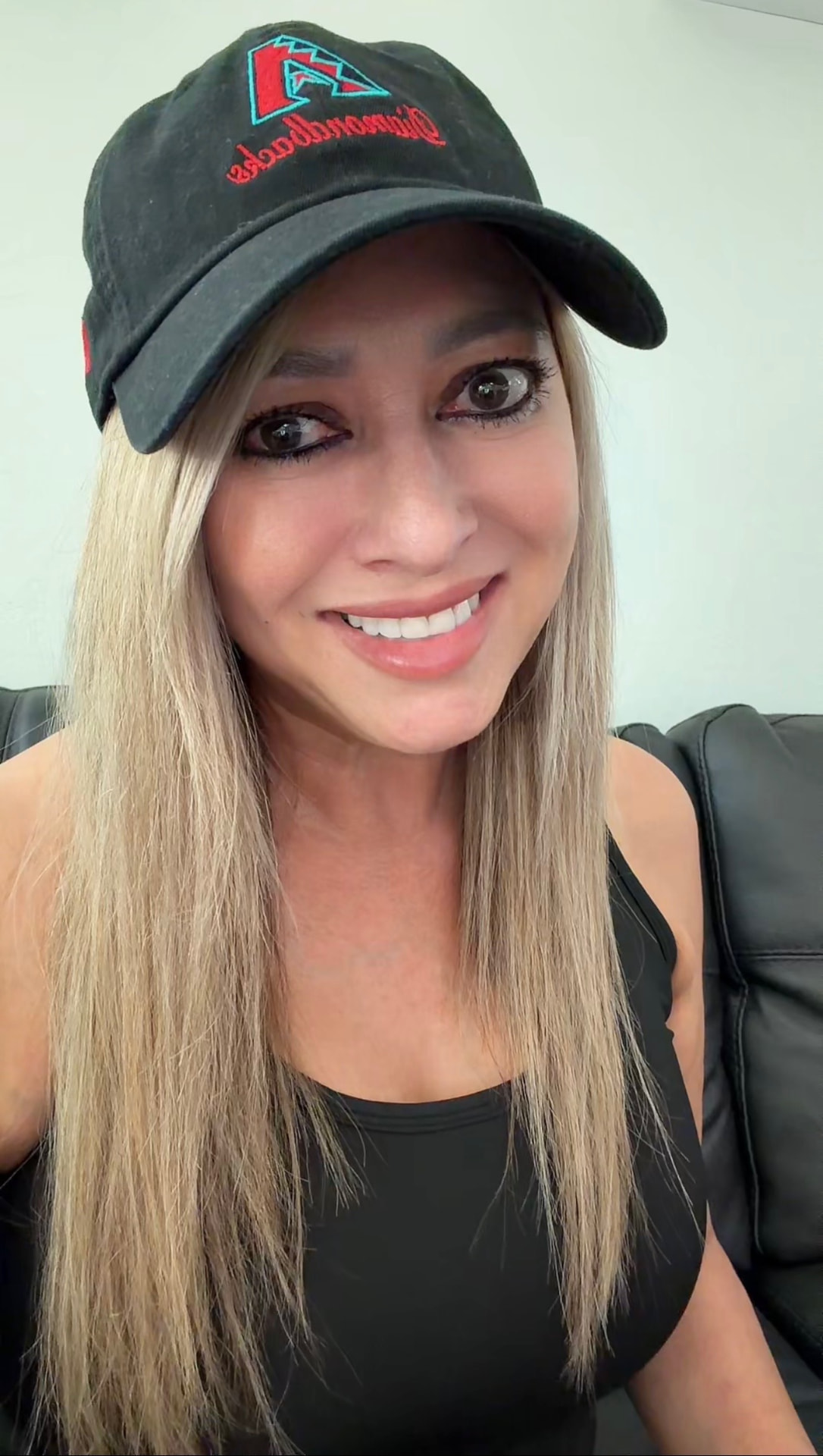 Sabrina Vargas, North Peoria real estate agent, smiling in a casual portrait wearing a Diamondbacks cap.